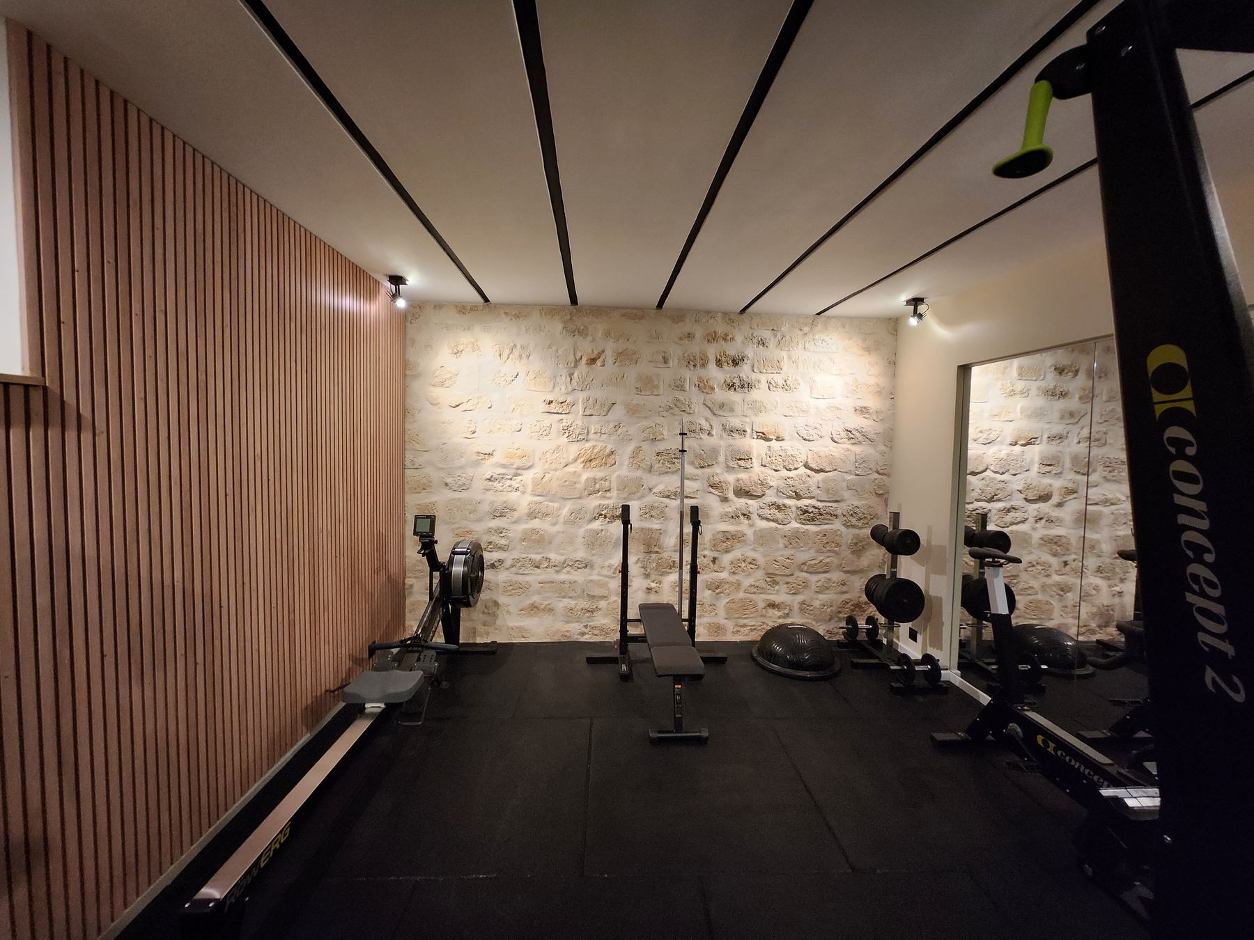 Studio JSport Guy Môquet, mur en pierre, rameur et banc de musculation
